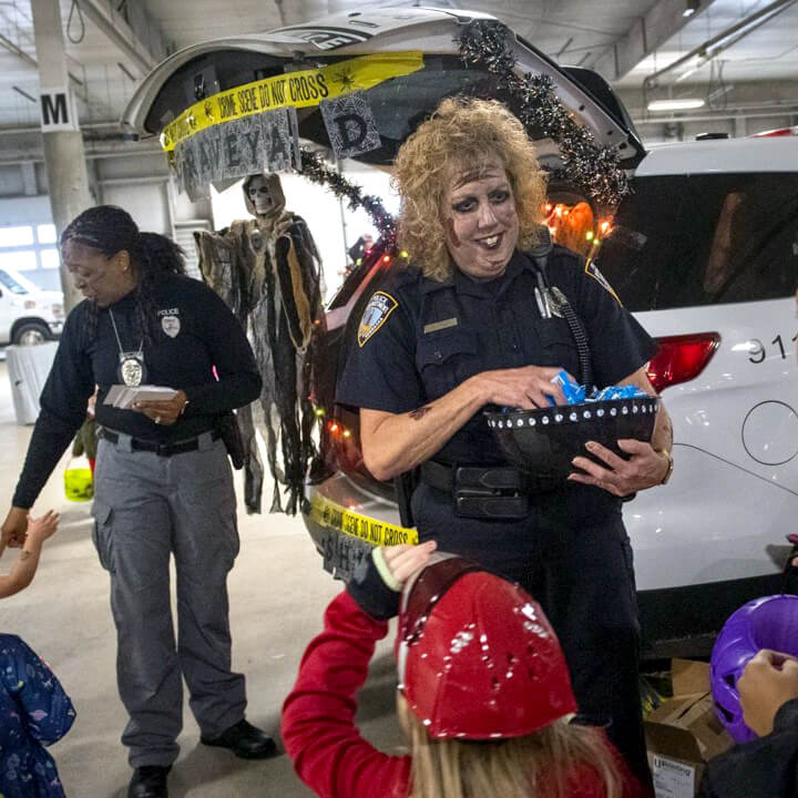 Nebraska State Patrol officers hand out candy to small children at a trunk or treat event hosted at Sandhills Global Event Center